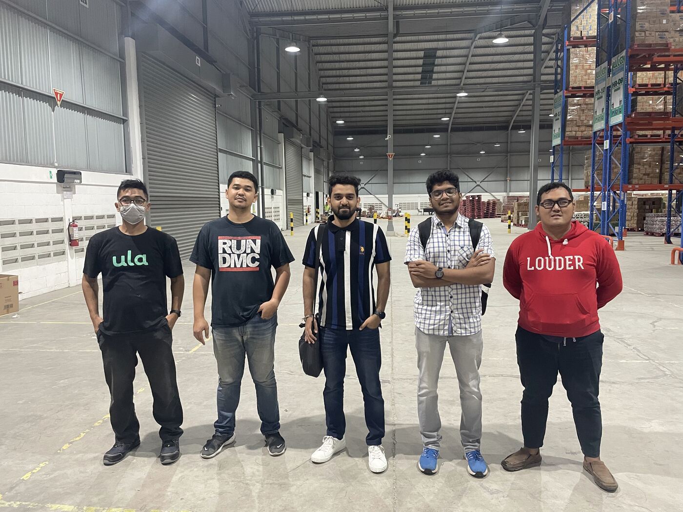 Shivam with teammates in a warehouse